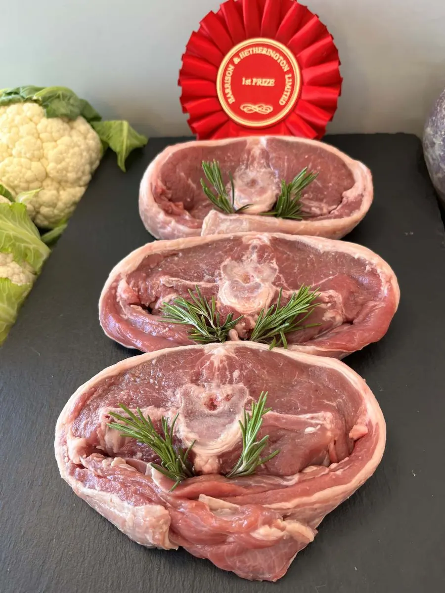 Three Barnsley lamb chops with rosemary beside a prize rosette