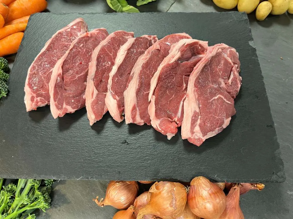 Row of lamb chump steaks on slate