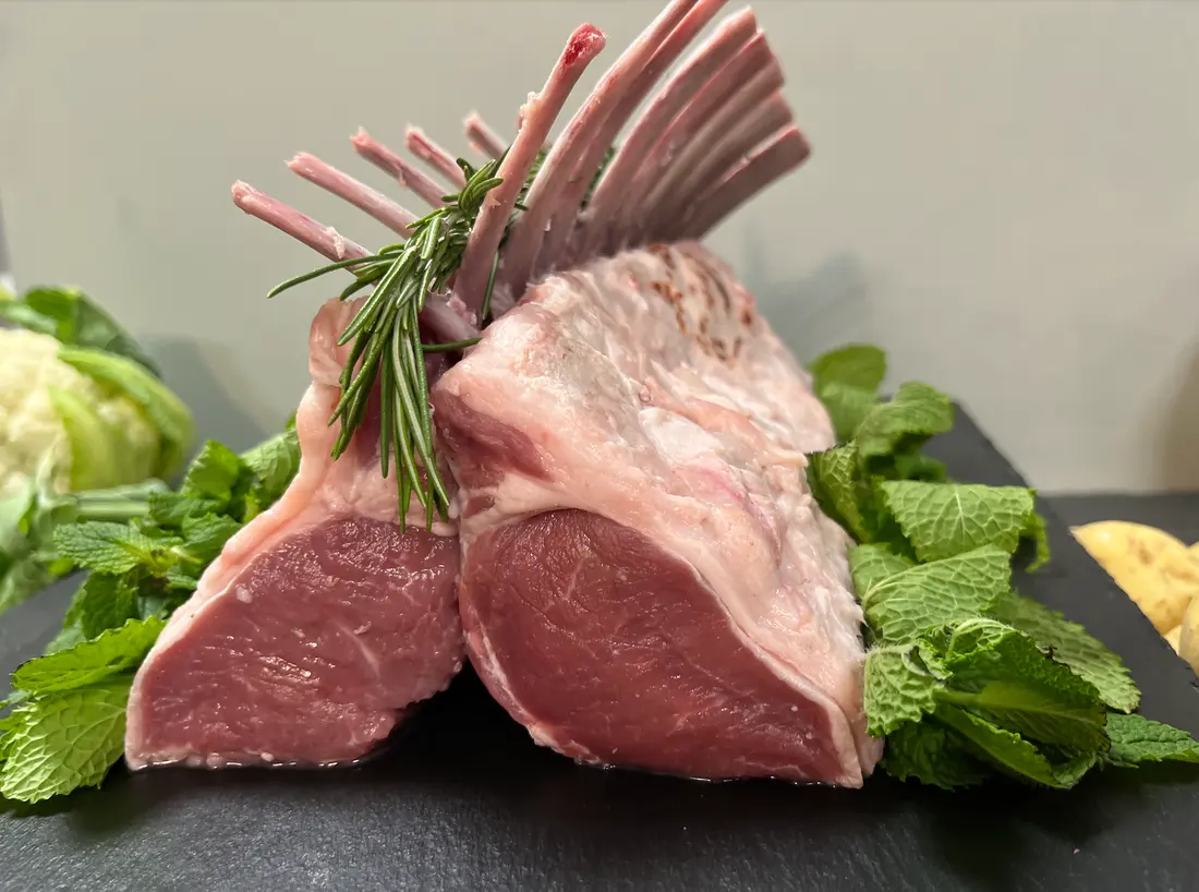 French-trimmed rack of Cheshire Prime Lamb on slate with fresh mint